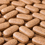 Close-up of brown pill tablets arranged in a pattern